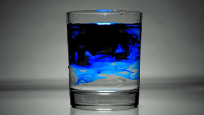 蓝色着色剂溶解在一杯水中