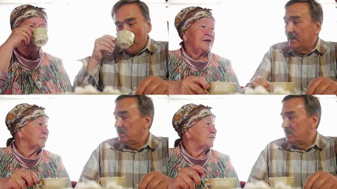 一对老年夫妇正在用老式的俄罗斯水壶茶炊喝茶。一个留着小胡子的男人和妻子穿着方巾说话