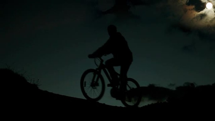 夜间骑自行车的人在月光下骑自行车