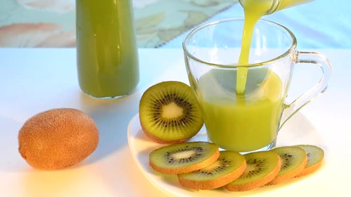 猕猴桃汁倒入玻璃杯中，接下来是盘子上的水果。选择性聚焦。