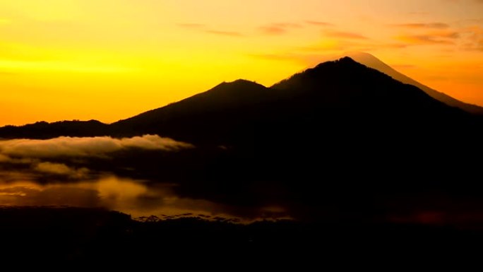 背景上的巴图尔湖、阿贡火山和阿邦火山上空日出。巴厘岛