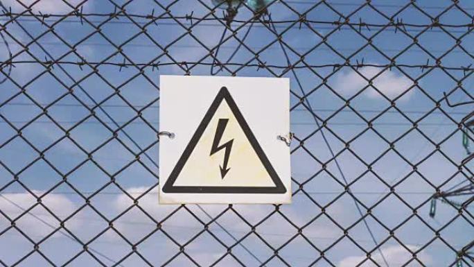 高压损坏的危险迹象。网的电力。围栏后面的变电站。危险的警告信号。高电压。带支撑的电线
