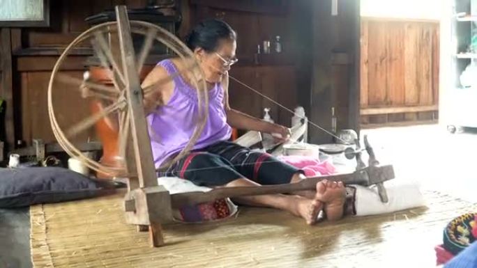 泰国祖母在家里选址并编织纺织品
