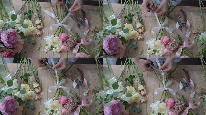 女花店的手在木桌上摆放花束。顶视图
