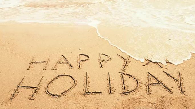 节日快乐!写在沙滩上。假日概念。