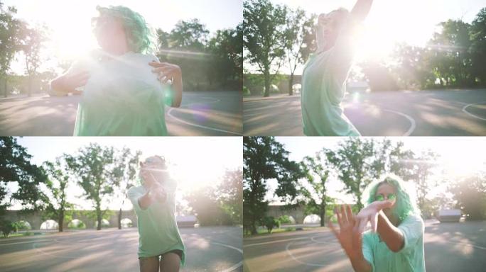 年轻时尚时髦的女孩，绿色头发和太阳眼镜，户外跳舞，慢动作