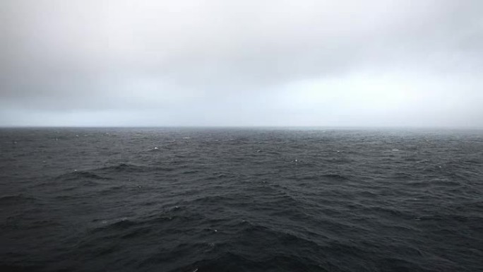 多雾的早晨，在喜怒无常的海上，天空多云，可以看到一艘移动的游轮
