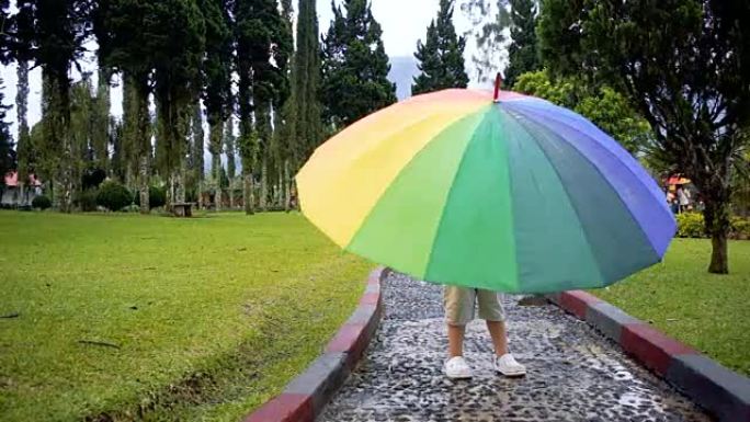 小男孩正在旋转彩虹伞