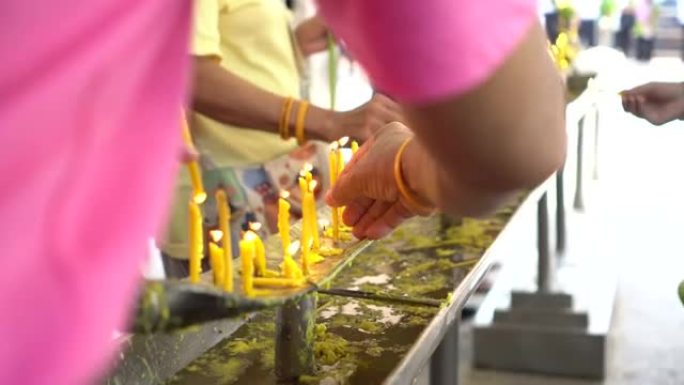 泰国清迈佛教寺庙的手点燃蜡烛