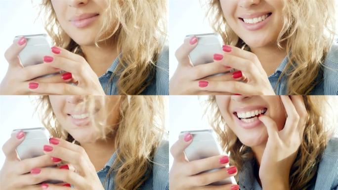 微笑着在智能手机上打字的女人。照片中手的特写可以看到拿着手机，嘴唇变成了微笑