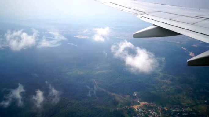 飞机窗户视图在地球景观和云上方飞行