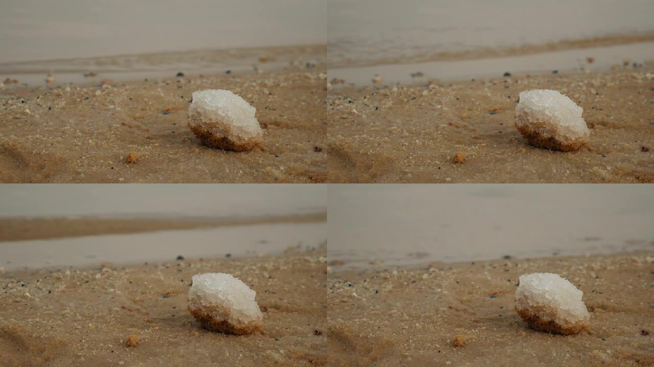 关闭以色列死海沙滩上的盐沉积物。背景上的水。