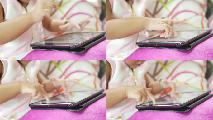 使用数字平板电脑的小女孩的特写手指