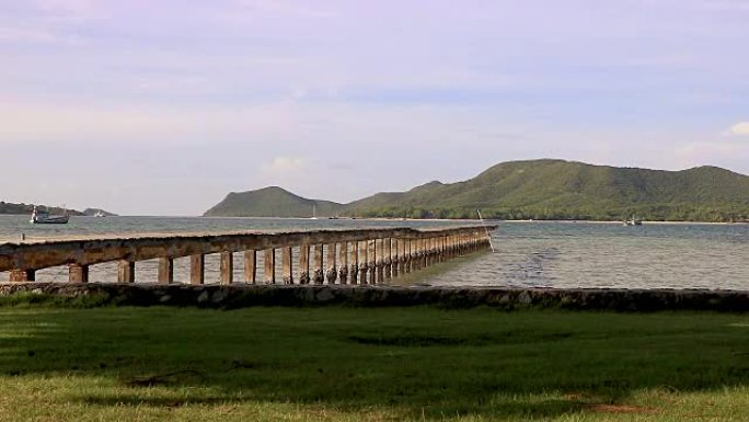 海滨气氛在早晨的岸边绿草和木桥延伸到海中。
