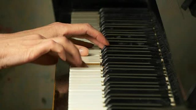 女性的手在优美的三角钢琴上演奏着轻柔的古典音乐。弹钢琴的女人，特写。