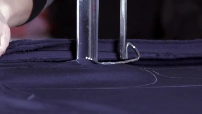 裁缝保持织物手感并切割蓝色织物