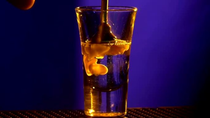 酒保的手用蓝色的白色液体制作鸡尾酒，射击，慢动作