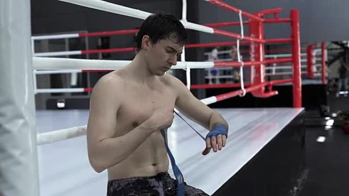 男性拳击手在训练前用蓝色的手包手