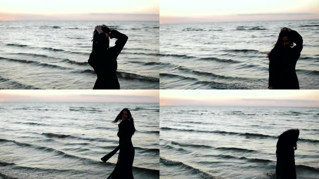 穿着深色连衣裙的女孩在海滩上的水上摇头舞。拍照。模。海
