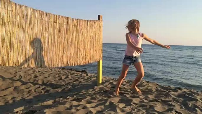 Yopung女孩在沙质海岸上与hir shadow跳舞