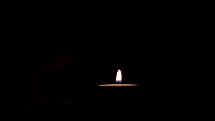 蜡烛点燃的特写镜头在黑色背景上匹配。