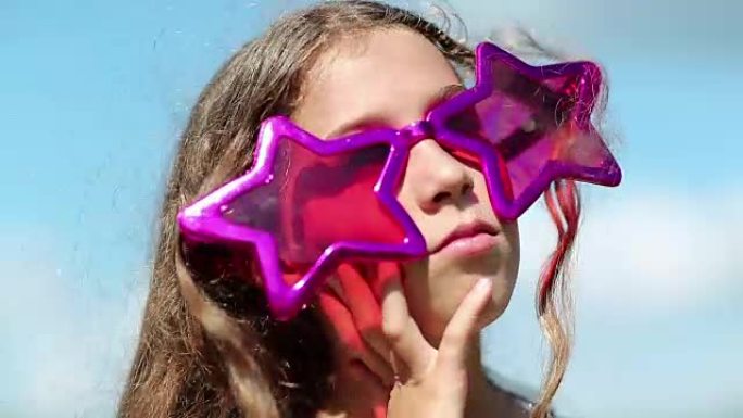 戴着星星形状的大粉红色眼镜的女孩环顾四周并思考