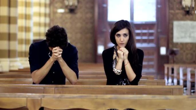 在教堂里祈祷的夫妇