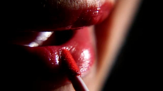 女人用口红画嘴唇，特写