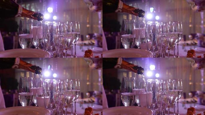 服务员在酒杯里倒香槟，在餐厅里，服务员在水晶杯里倒香槟，餐厅内部，自助餐桌，戴着白手套的服务员，特写