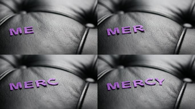 单词 “mercy” 的字母出现在黑色皮革上