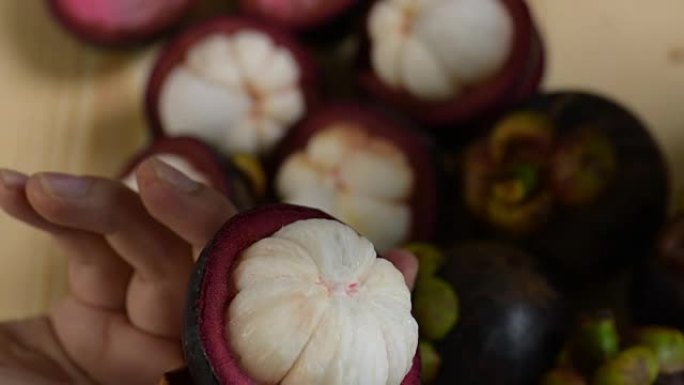 手工表演山竹切成薄片的紫色皮肤和水果女王的白色果肉