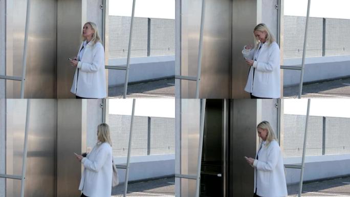 金发女人在等待电梯时在手机上发短信