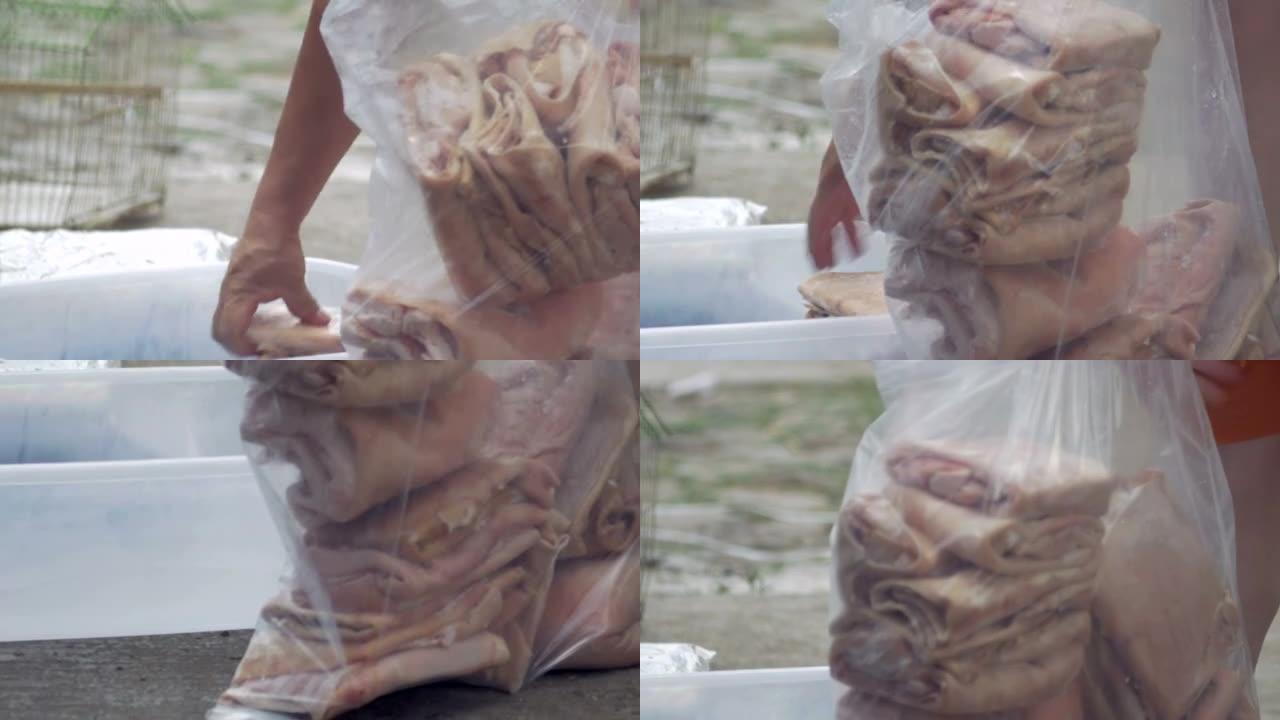 男人将未煮熟的猪皮装进塑料袋中，用于chicharroone