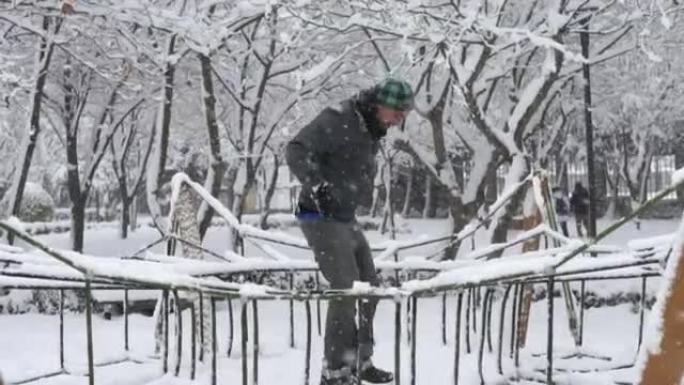 一个男人在冬天跳上公园的设备