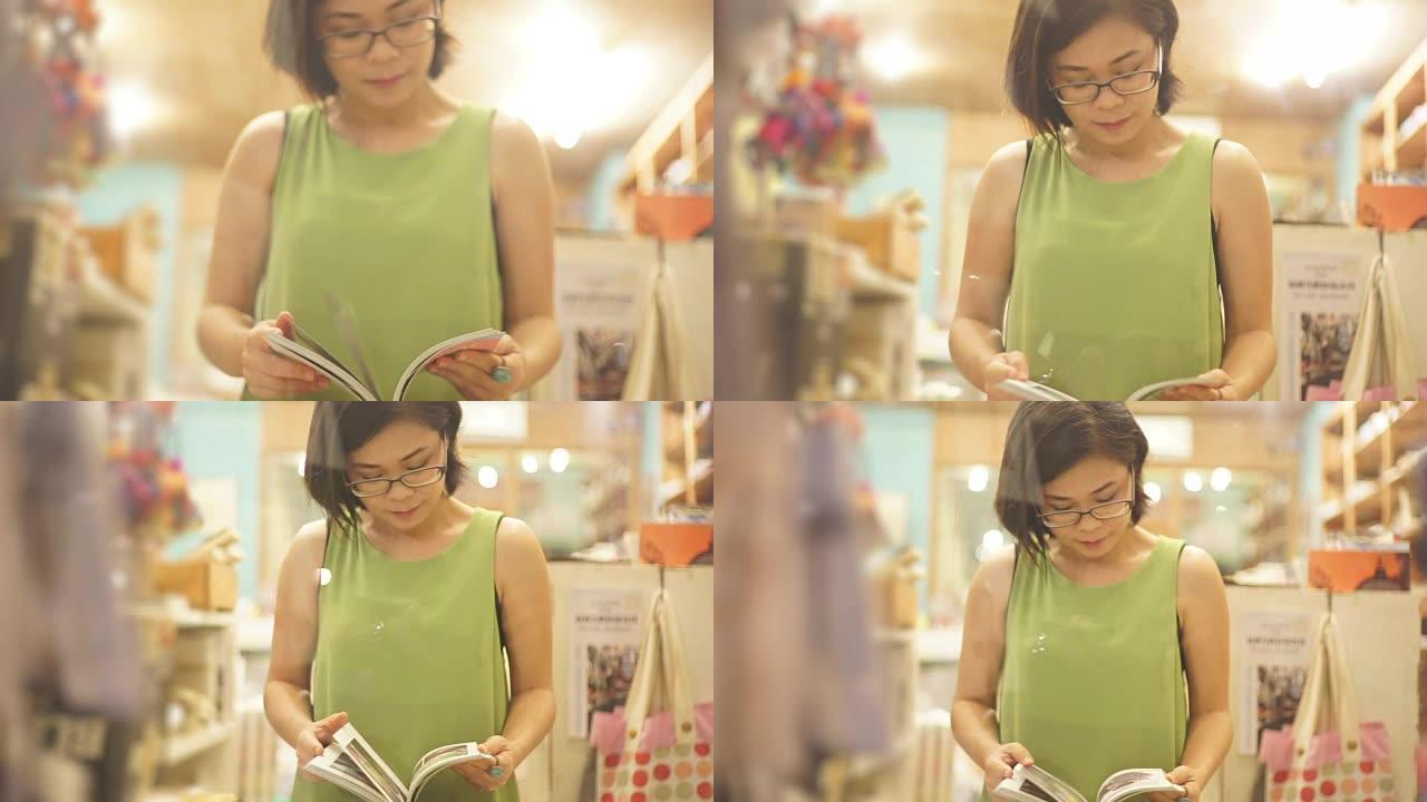 亚洲妇女在书架背景下在书店看书。
