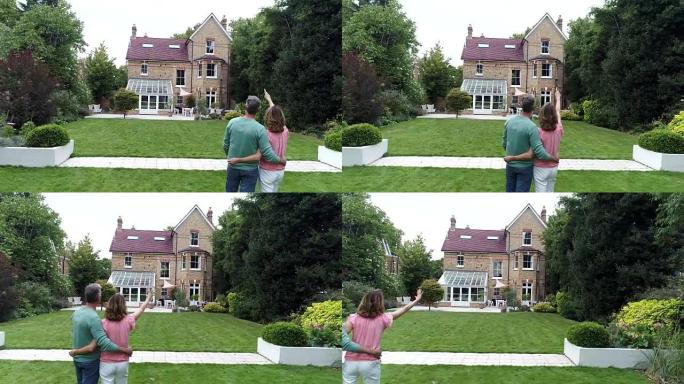 夫妇站在家庭住宅外的后花园中拍摄的照片