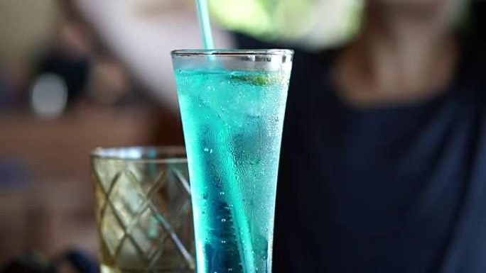 蓝色海洋鸡尾酒，无酒精鸡尾酒特写。绿松石饮料中的火花苏打质地
