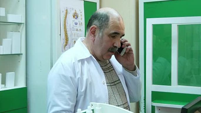 高级药剂师在药房检查处方时在手机上聊天