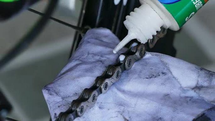 专业机械师在自行车上设置带油润滑的链条