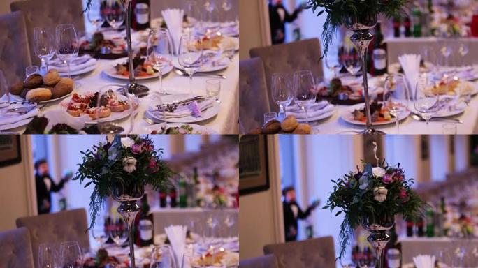 精美的婚礼装饰由不同种类和颜色的花朵制成，放在高档餐厅的婚礼桌上。