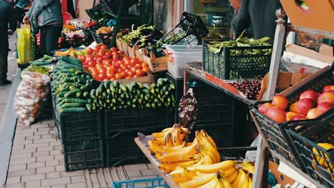 市场柜台上有很多新鲜蔬菜。买家会选择新鲜的西红柿，土豆，辣椒，豆类，樱桃，香蕉。市场上的买方和卖方。