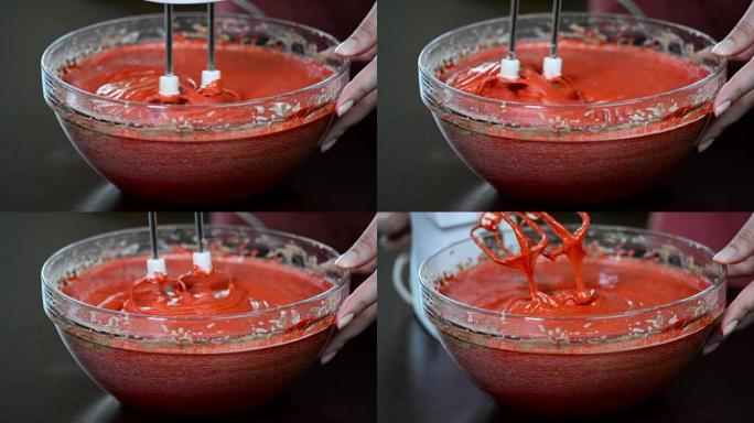 用电动搅拌机敲打面团特写。制作红色天鹅绒蛋糕