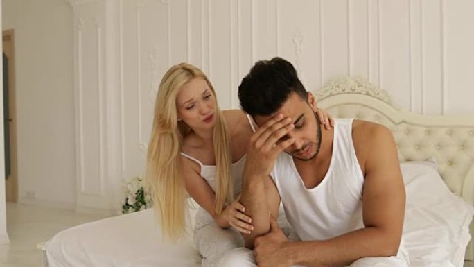 夫妻问题男人坐在床上不快乐的女人安慰他消极情绪慢动作