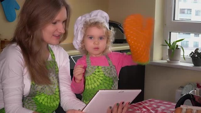 可爱的家庭女孩平板电脑在网上寻找蛋糕食谱