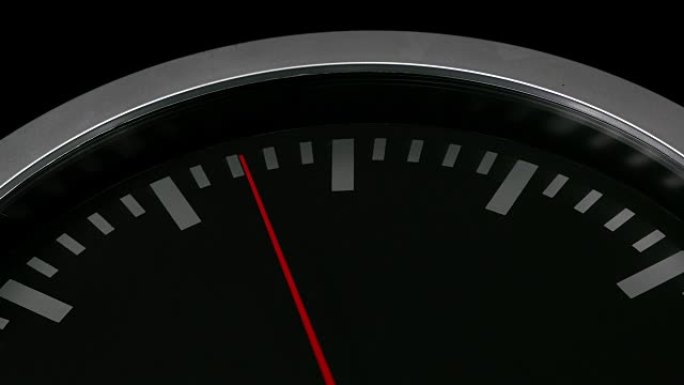 封闭在黑色背景上的黑色挂钟。红色秒针路过