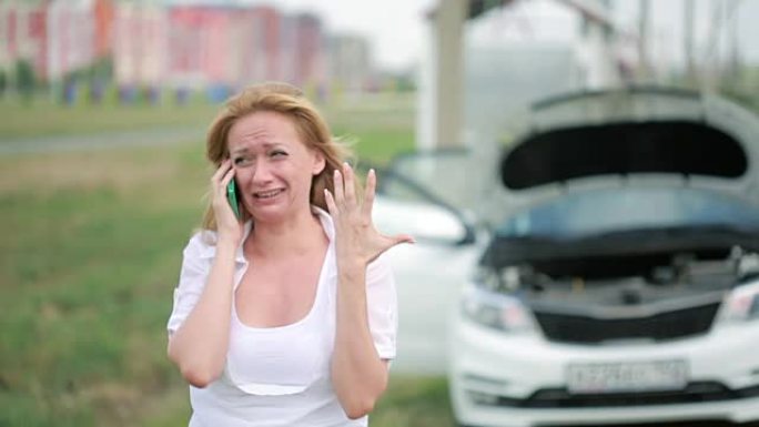 女人和破车用手机呼救。女人哭泣