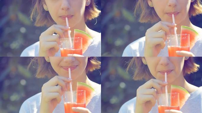 年轻女子喝新鲜的西瓜汁。