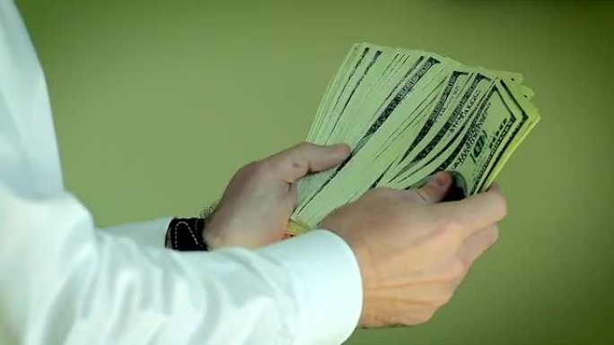 男人数着他的钱。数百美元钞票