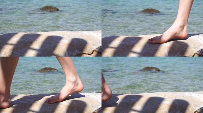 女性的腿在海边散步