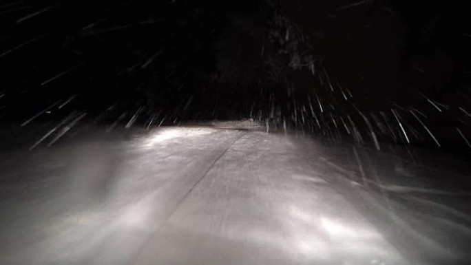 夜间驾车穿越雪道冬林